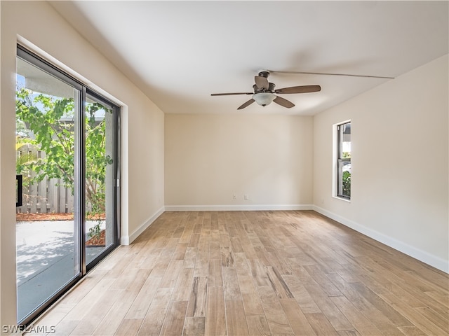 empty room with light hardwood / wood-style flooring, a wealth of natural light, and ceiling fan