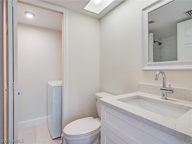 bathroom featuring tile patterned flooring, washer / dryer, toilet, and vanity