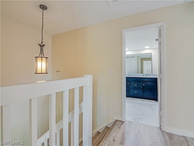 hall with light hardwood / wood-style flooring and sink