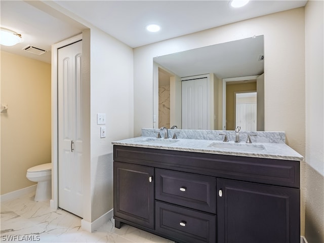 bathroom with dual vanity, toilet, and tile patterned floors