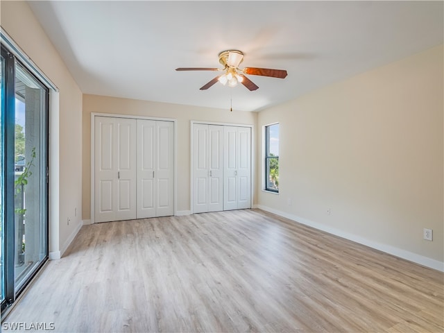 unfurnished bedroom with two closets, light wood-type flooring, ceiling fan, and access to exterior