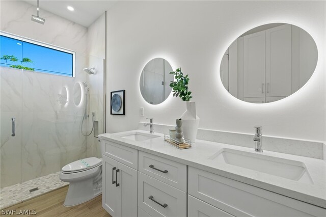 bathroom featuring hardwood / wood-style floors, vanity, a shower with door, and toilet