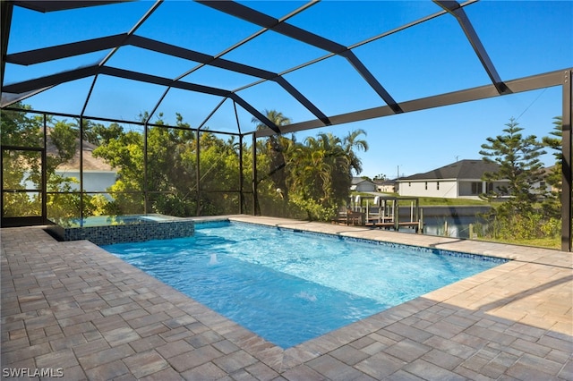 view of pool with a lanai, a patio area, a water view, and an in ground hot tub