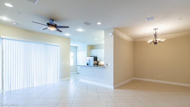 interior space featuring ceiling fan with notable chandelier and light tile patterned floors