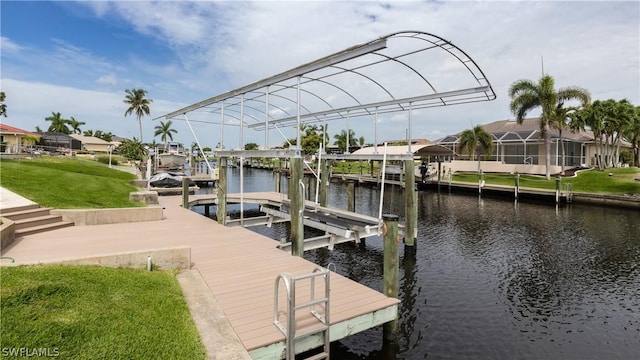 dock area with a lawn and a water view