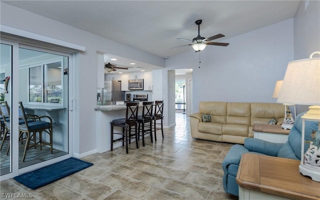 living room featuring ceiling fan and lofted ceiling