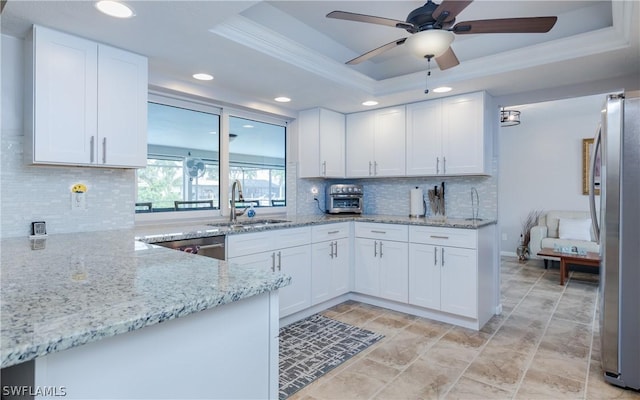 kitchen with sink, white cabinetry, a raised ceiling, and stainless steel appliances