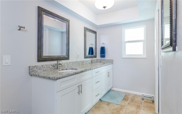 bathroom with a raised ceiling and vanity