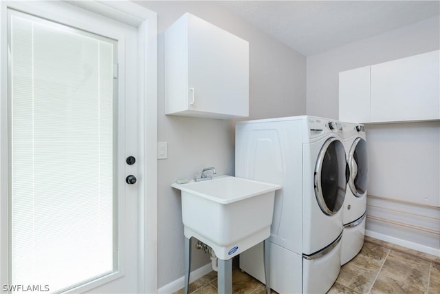 washroom featuring sink, cabinets, and independent washer and dryer