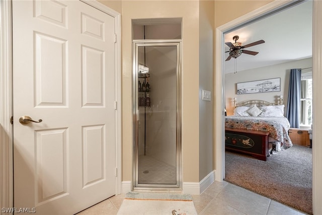 bathroom featuring a shower with door, tile patterned flooring, and ceiling fan