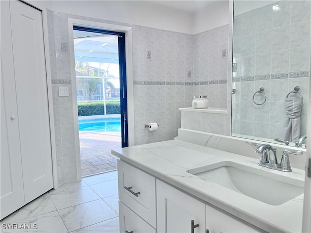 bathroom featuring vanity and tile walls