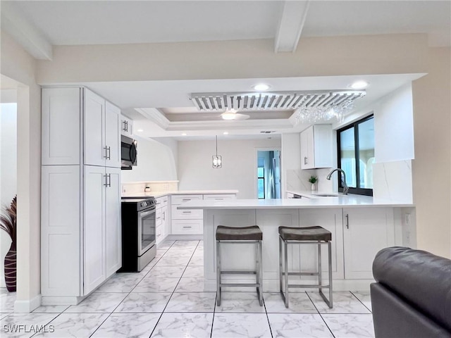 kitchen featuring white cabinetry, stainless steel appliances, and kitchen peninsula