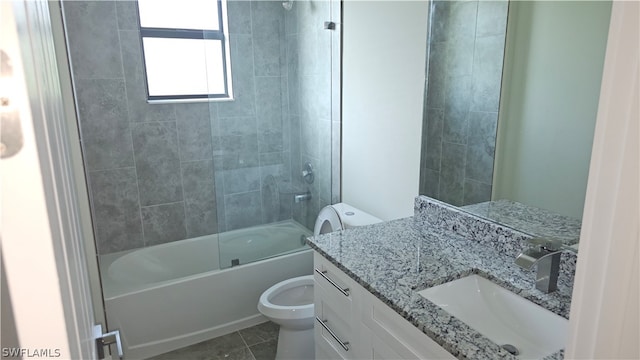 full bathroom featuring vanity, tiled shower / bath, tile patterned flooring, and toilet