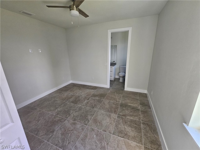 spare room featuring ceiling fan and dark tile patterned flooring