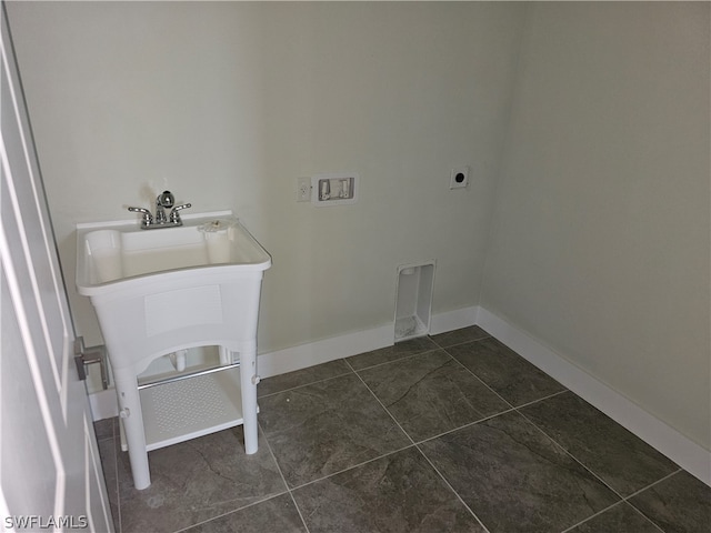 laundry room with electric dryer hookup and dark tile patterned flooring