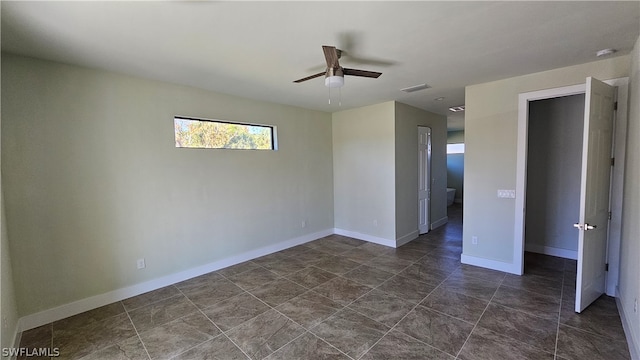 unfurnished bedroom featuring ceiling fan and dark tile patterned flooring