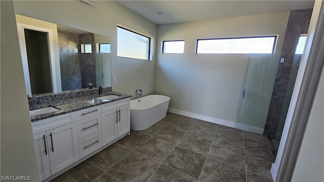 bathroom featuring tile patterned floors, double sink vanity, a bath, and a wealth of natural light