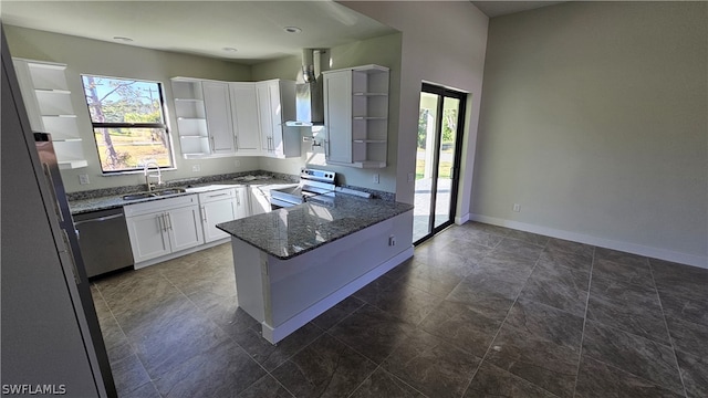 kitchen with appliances with stainless steel finishes, white cabinets, sink, dark tile patterned flooring, and dark stone countertops