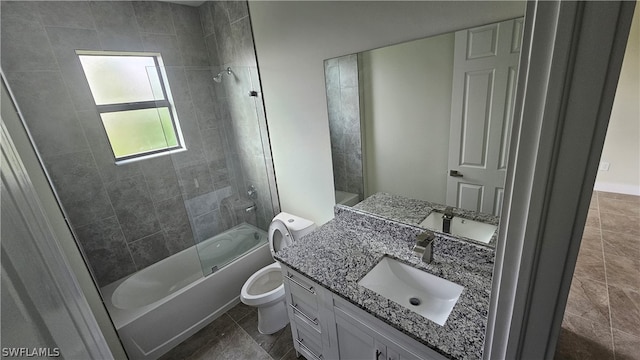 full bathroom featuring tile patterned flooring, toilet, vanity, and tiled shower / bath