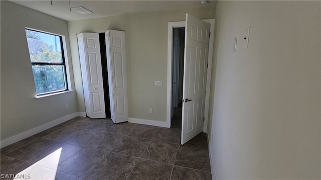 unfurnished bedroom with dark tile patterned flooring