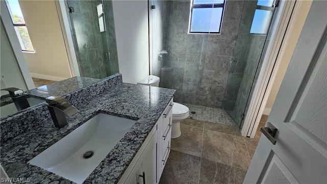 bathroom featuring tile patterned floors, a shower with door, toilet, and double sink vanity