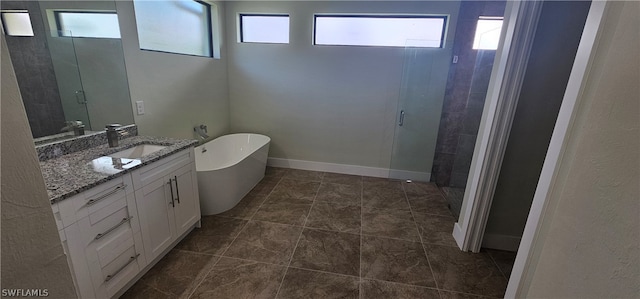 bathroom featuring vanity, tile patterned floors, and a tub to relax in