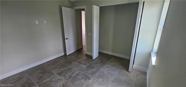 unfurnished bedroom with dark tile patterned floors and a closet