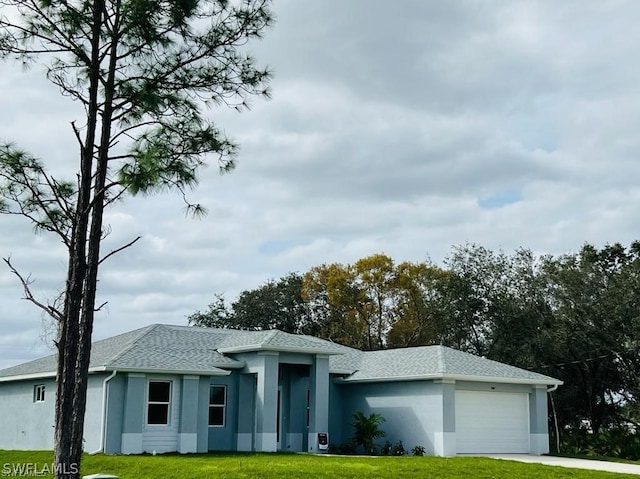 view of front of home with a front yard and a garage