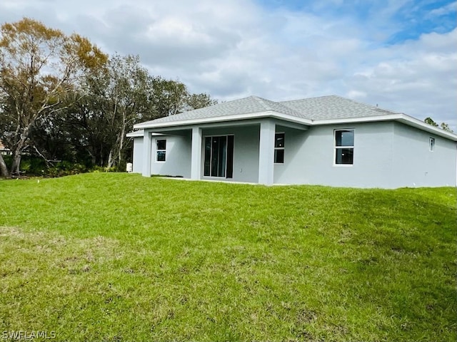 rear view of property featuring a lawn