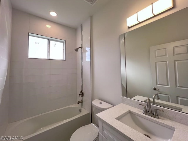 full bathroom with tiled shower / bath, toilet, and vanity