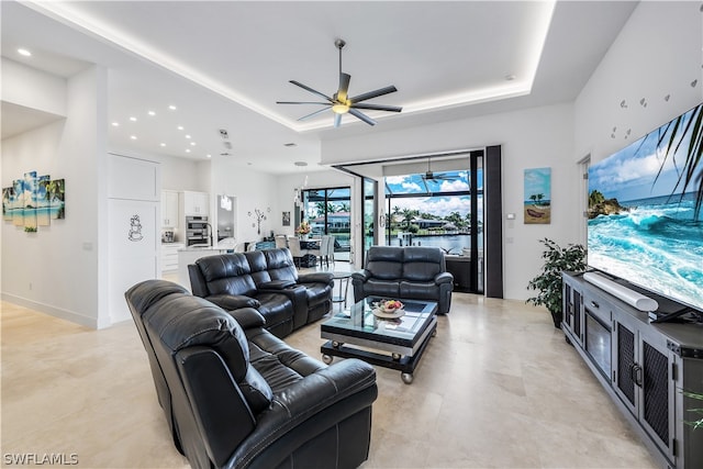 living room featuring a tray ceiling and ceiling fan