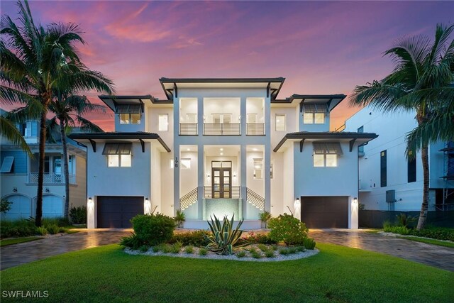 175 Conners Ave, Naples, FL 34108 - view of front facade with an attached garage, stucco siding, decorative driveway, and a balcony