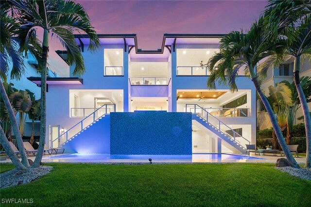 175 Conners Ave, Naples, FL 34108 - back of house with stairs, a yard, stucco siding, and an outdoor pool