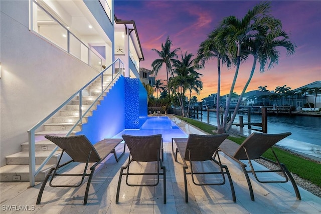 175 Conners Ave, Naples, FL 34108 - patio terrace at dusk with stairs, a water view, an outdoor pool, and a patio