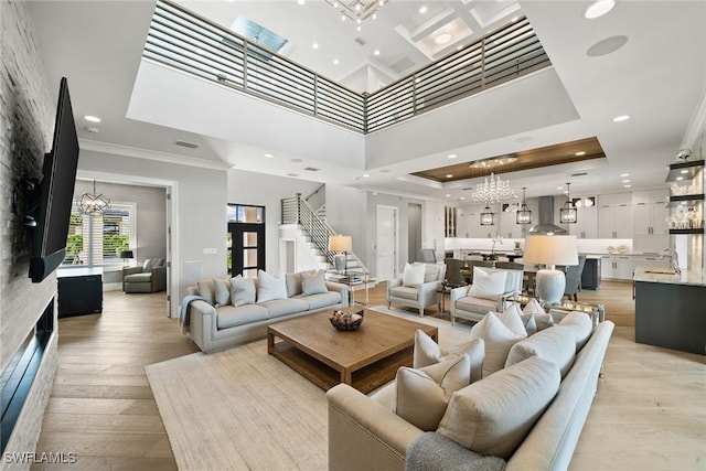 living room featuring light hardwood / wood-style floors, ornamental molding, and a high ceiling