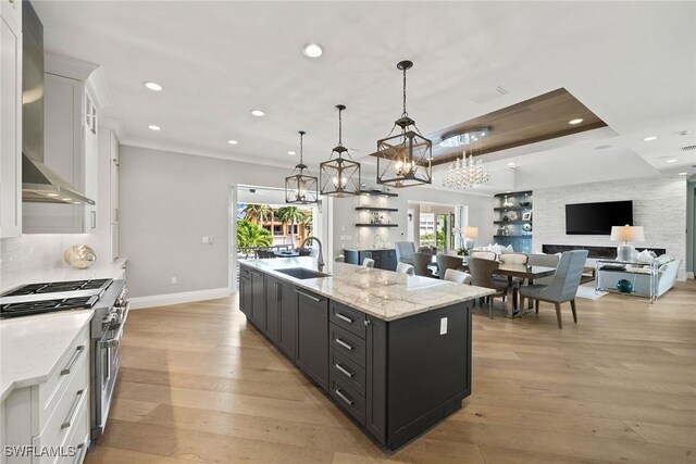 175 Conners Ave, Naples, FL 34108 - kitchen featuring high end stainless steel range, wall chimney exhaust hood, a sink, white cabinets, and recessed lighting