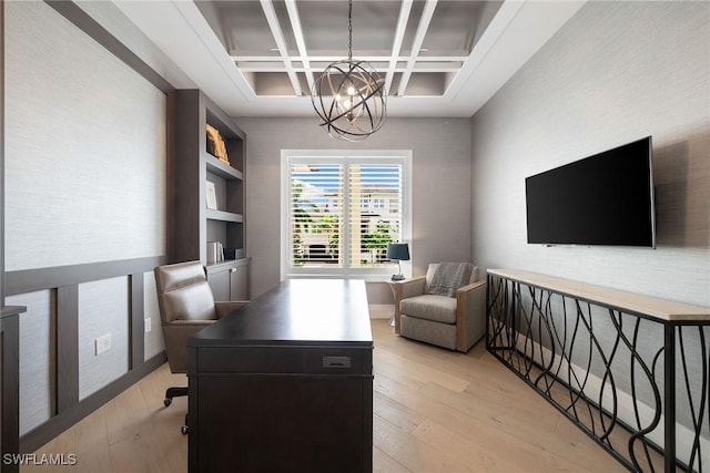 office space with a chandelier, beam ceiling, light wood-type flooring, and coffered ceiling