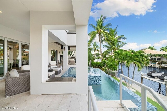175 Conners Ave, Naples, FL 34108 - view of pool featuring a water view, an outdoor living space, a patio area, area for grilling, and an outdoor bar