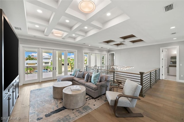 living room with beamed ceiling, ornamental molding, coffered ceiling, and light wood-type flooring