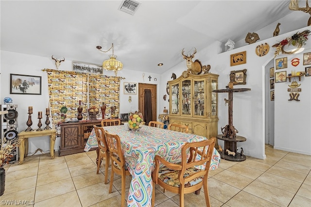 dining space with light tile patterned flooring and vaulted ceiling