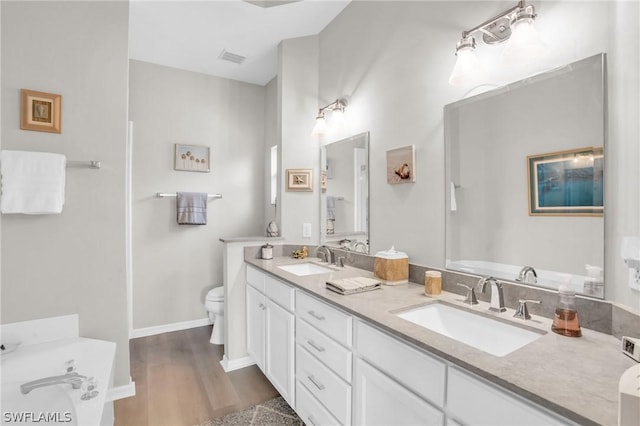 bathroom featuring toilet, vanity, and hardwood / wood-style floors