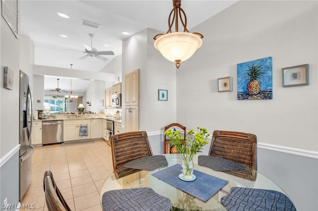 dining area featuring ceiling fan, light tile patterned flooring, and high vaulted ceiling