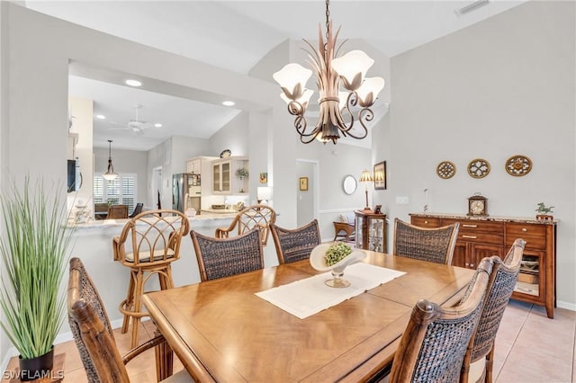 tiled dining room featuring lofted ceiling and ceiling fan with notable chandelier