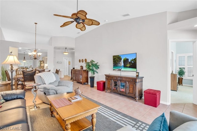 living room with light tile patterned floors, vaulted ceiling, and ceiling fan with notable chandelier