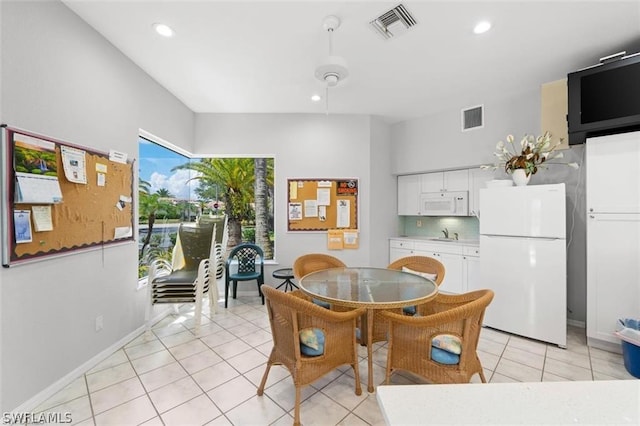 dining space featuring light tile patterned floors and sink