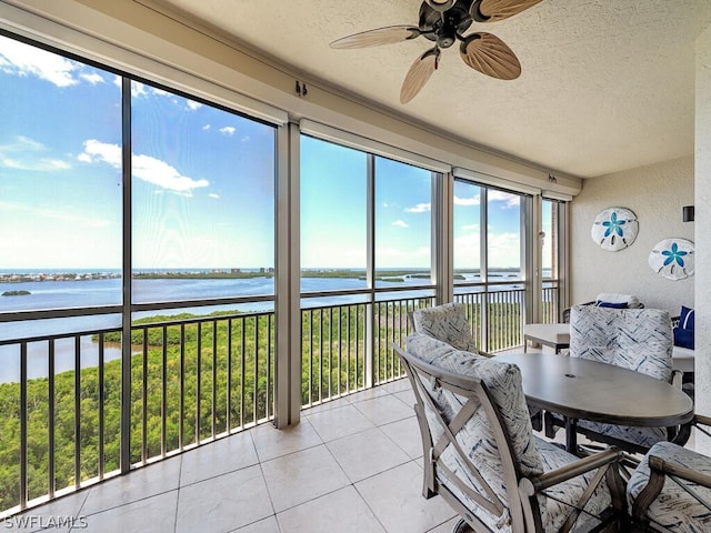 sunroom with a water view and ceiling fan