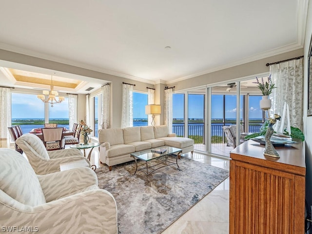 living room featuring ornamental molding, a water view, plenty of natural light, and a chandelier