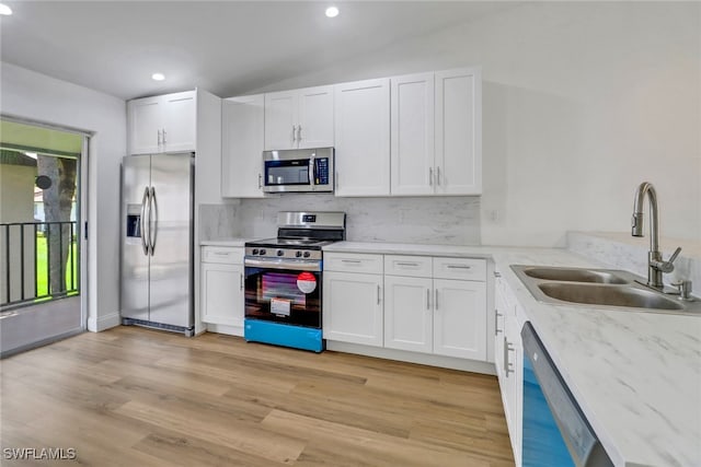 kitchen featuring appliances with stainless steel finishes, light hardwood / wood-style floors, white cabinetry, and sink