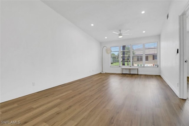 unfurnished living room featuring ceiling fan, radiator heating unit, and hardwood / wood-style flooring