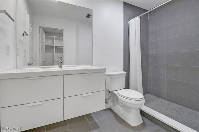 bathroom with tile patterned floors, vanity, toilet, and curtained shower